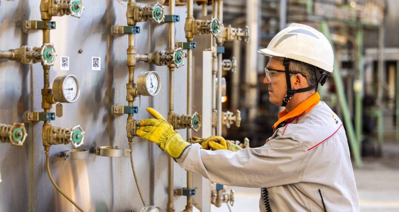 Operario de la refinería trabajando con unas válvulas